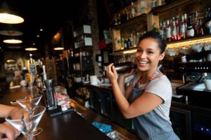 Portrait of a happy female bartender mixing drinks at a bar in a cocktail mixer Wedding Bar